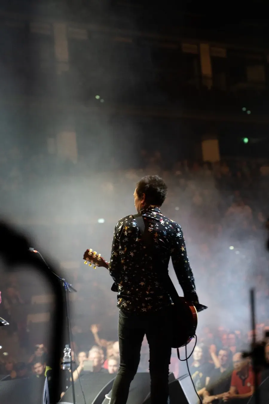 The guitarist of Wishbone Ash from behind, looking out into the crowd